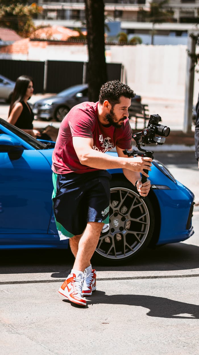 A filmmaker concentrating with a camera stabilizer outdoors, capturing dynamic city scenes.